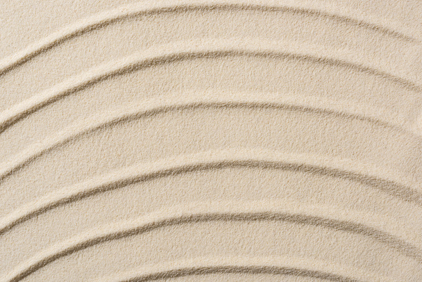 Widok z góry na teksturowane tło z piaskiem i gładkimi liniami - Zdjęcie, obraz