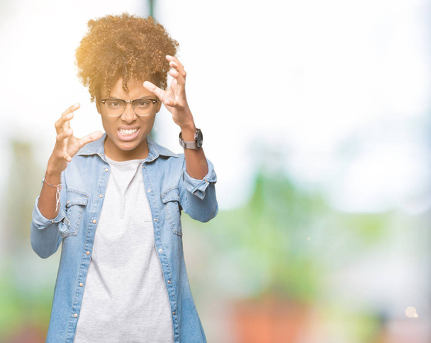 Güzel genç Afro-Amerikan kadın üzerinde gözlük takan arka plan boğazlamak istiyor eller öfke ile sinirli bağıran kızgın bağırıyor izole - Fotoğraf, Görsel