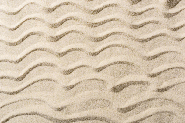 Κορυφαία όψη της υφής φόντο με άμμο και λεία κύματα  - Φωτογραφία, εικόνα