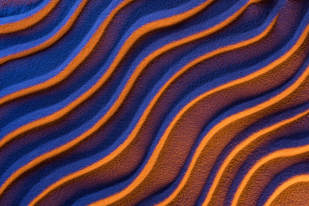 Draufsicht auf strukturierten Sand mit sanften Wellen und neonfarbenem Filter - Foto, Bild