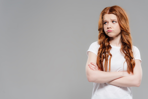 beautiful upset redhead girl with crossed arms isolated on grey with copy space - Foto, imagen
