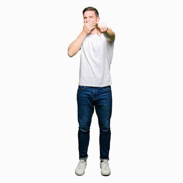 Pohledný muž nosí ležérní bílé tričko rajským vás, ukazující na fotoaparát s prsty rukou ústa, Škoda výraz - Fotografie, Obrázek