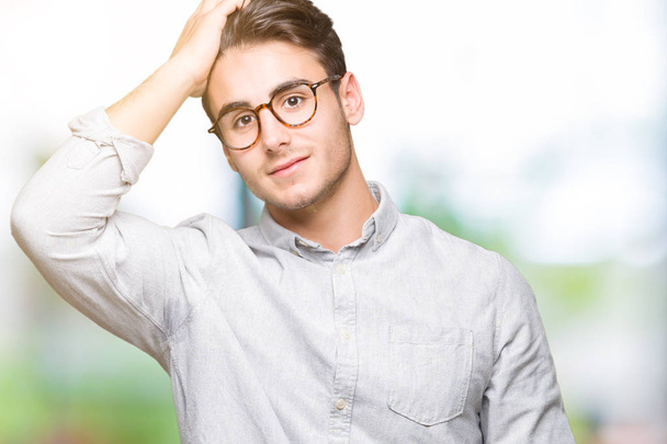Mladý pohledný muž nosí brýle izolované pozadí usmívající se jistý dojemné vlasy rukou nahoru gesto, které představují atraktivní - Fotografie, Obrázek