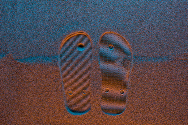 top view of flip flops mark on sand with color filter - Photo, Image