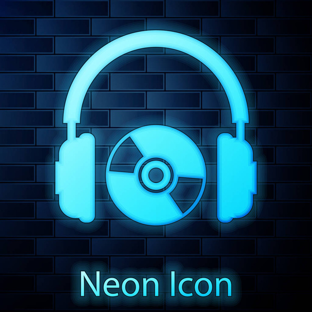 leuchtende Neon-Kopfhörer und CD- oder DVD-Symbol isoliert auf Backsteinwand Hintergrund. Kopfhörerzeichen. Compact Disk Symbol. Vektorillustration - Vektor, Bild