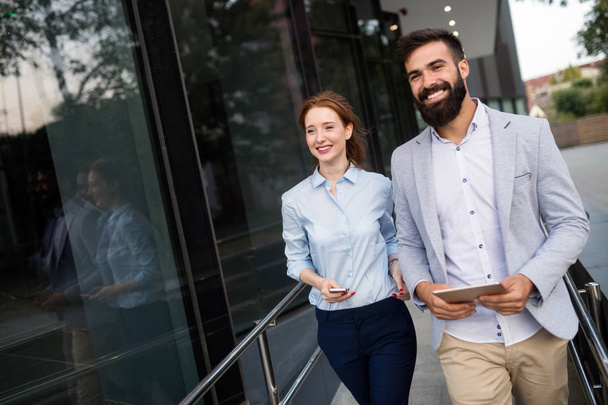 Young attractive business couple walking outdoor near office building - Foto, imagen