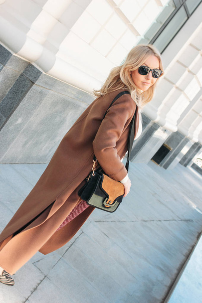 Mulher elegante moda vestindo casaco bege com cabelo louro encaracolado na rua
 - Foto, Imagem