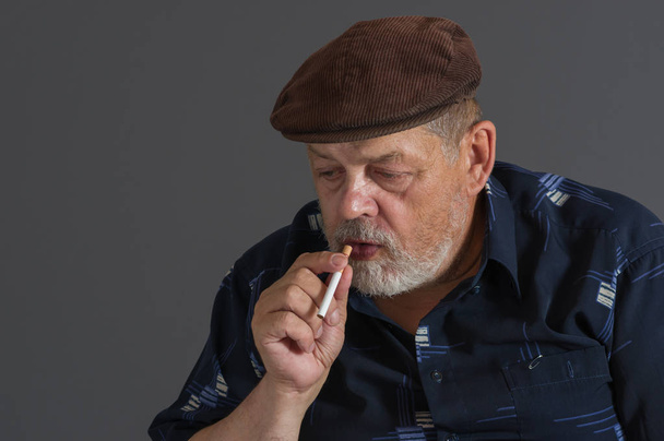 Bonito retrato de hombre mayor caucásico vacilante con cigarrillo
  - Foto, Imagen