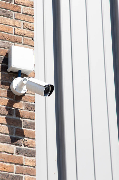 Vivienda de cámara de seguridad de vídeo montada en alto en el edificio
 - Foto, imagen