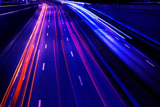  Cars light trails on a curved highway at night. Night traffic trails. Motion blur. Night city road with traffic headlight motion. Cityscape. Light up road by vehicle motion blur. - Foto, afbeelding