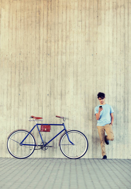 man with smartphone and fixed gear bike on street - Foto, imagen