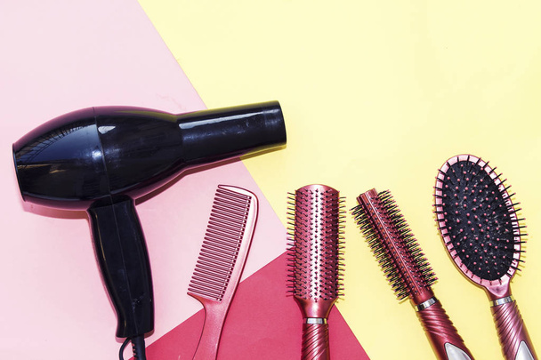 Outils professionnels de coiffure et sèche-cheveux noir isolé sur fond coloré avec espace de copie
 - Photo, image