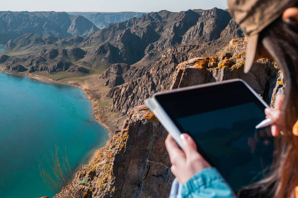 A menina desenha a paisagem de primavera do rio no tablet gráfico. Focada na paisagem
 - Foto, Imagem