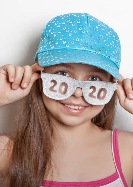 Girl in cap and glasses with scratched date 2020 - Fotoğraf, Görsel