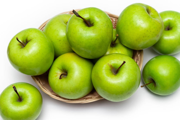 Manzanas verdes en una canasta sobre un fondo blanco - Foto, imagen