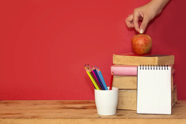 Επιστροφή στο σχολείο ιδέα, προμήθειες, χέρι κρατώντας μήλο φρούτα - Φωτογραφία, εικόνα