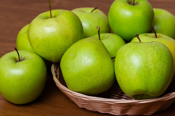 zelená jablka v košíku na dřevěném stole - Fotografie, Obrázek