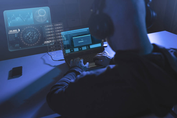 hacker with progress bar on laptop in dark room - Zdjęcie, obraz