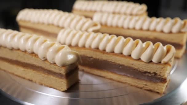 Pasteles con leche condensada y crema en soporte de torta giratoria en panadería
 - Metraje, vídeo