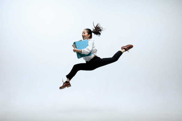 Woman working at office and jumping isolated on studio background - Foto, imagen