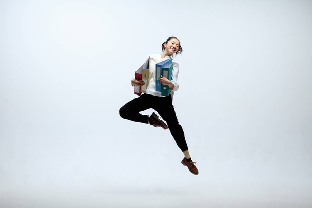 Woman working at office and jumping isolated on studio background - Fotografie, Obrázek