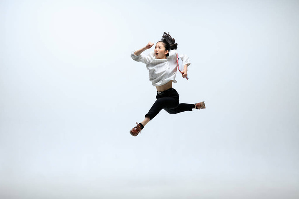 Woman working at office and jumping isolated on studio background - Фото, зображення