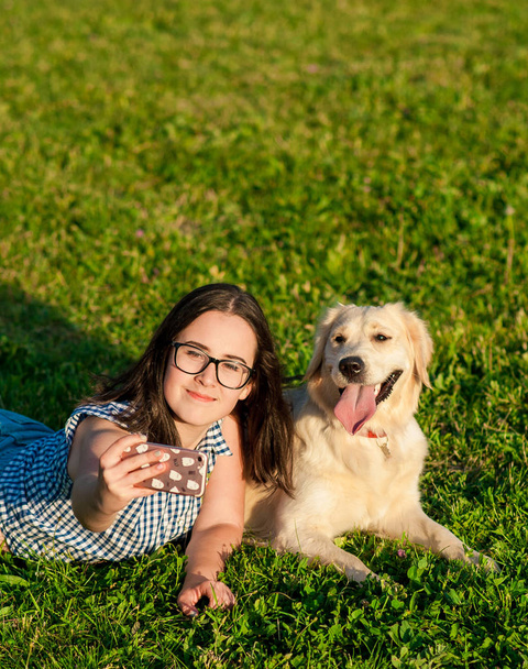 молода жінка і її дружня собака беруть селфі в парку
 - Фото, зображення