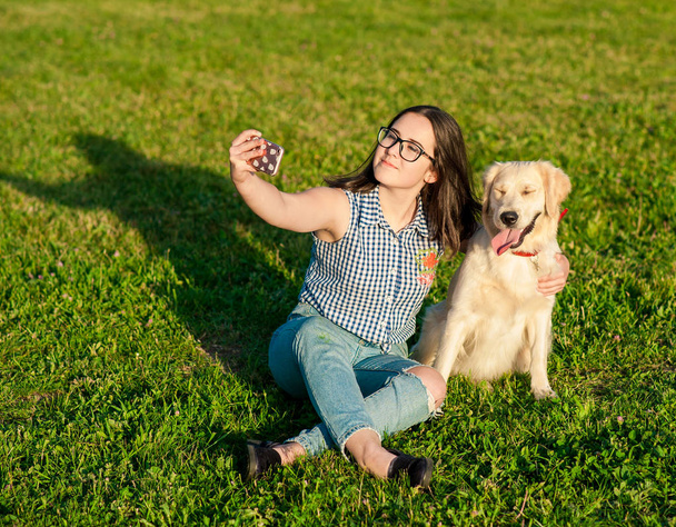 Portret van de jonge vrouw doet selfie met haar hond - Foto, afbeelding