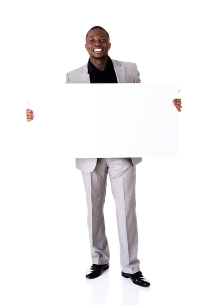 Happy successful businessman holding blank advertisement. - Zdjęcie, obraz
