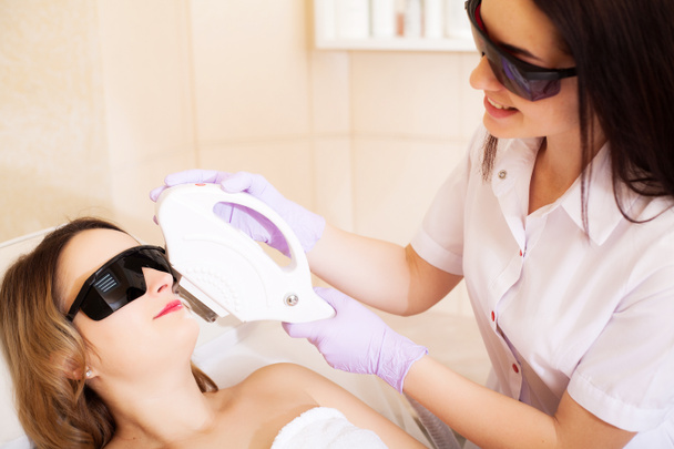 Body Care. Close-up of Beautician Giving Laser Epilation Treatment To Young Woman Face - Photo, Image