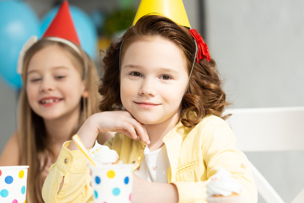 adorable kids in party caps during birthday celebration - 写真・画像