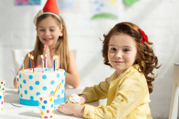 Doğum günü kutlama sırasında parti masasında oturan sevimli çocuklar - Fotoğraf, Görsel