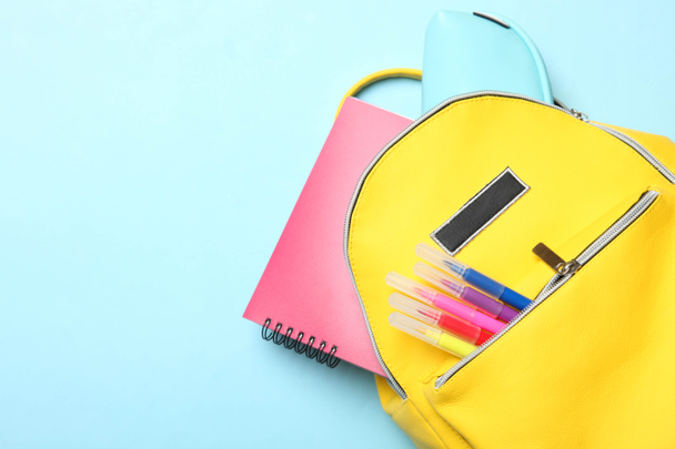 mochila amarilla con diferentes útiles escolares
 - Foto, Imagen