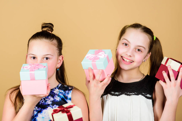 Oh happy day. Kids girls delighted gift. Girls adorable celebrate birthday. Kids happy loves birthday gifts. Shopping and holidays. Sisters enjoy presents. Children hold gift boxes beige background - Photo, image