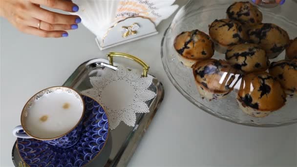 a cupcake was put on a silver tray with a cup of coffee - Filmati, video