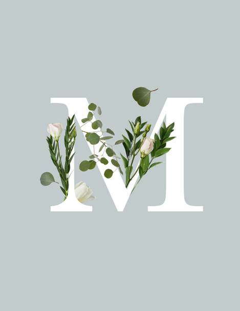 white letter M with flowers and green leaves isolated on grey - Photo, Image