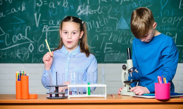 School education. Chemical analysis. Kids study chemistry. School chemistry lesson. School laboratory. Girl and boy communicate while conduct school experiment. Children studying together classroom - Photo, image