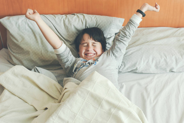 Boy stretching op het bed - Foto, afbeelding