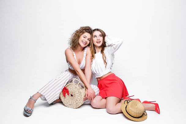 Two beautiful young women in trendy summer clothes posing at camera - Φωτογραφία, εικόνα