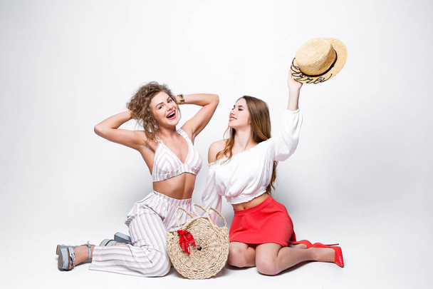Dos mujeres en trajes de verano de moda con estilo aislado sobre fondo blanco
 - Foto, imagen