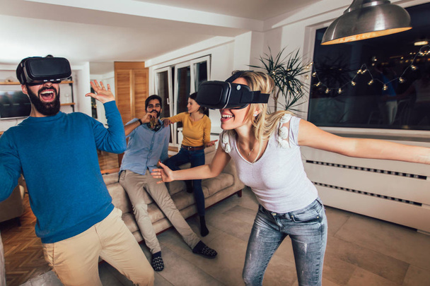 Young couple having fun with virtual reality headset glasses - H - Photo, Image