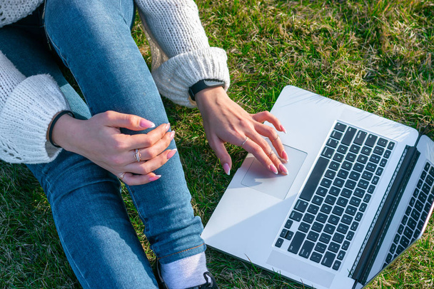 oříznutý zásah ženy pomocí laptopu na zelené trávě - Fotografie, Obrázek