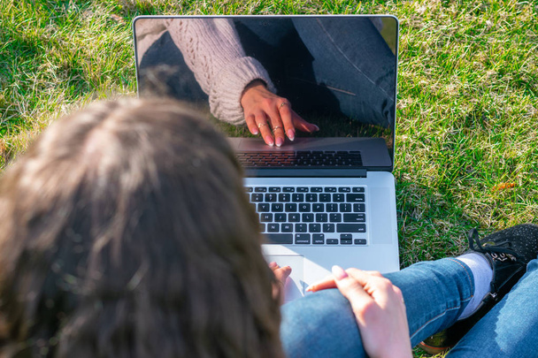 Schnappschuss von Frau mit Laptop auf grünem Rasen - Foto, Bild