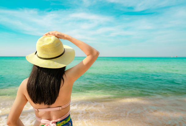 Hasır şapka ile mutlu genç Asyalı kadın arkadan görünüm rahatla ve tropik cennet plaj tatil keyfini çıkarın. Yaz tatil moda kız. Güzellik seksi modeli. Kum plaj. Yaz vibes. Yaz seyahat. - Fotoğraf, Görsel