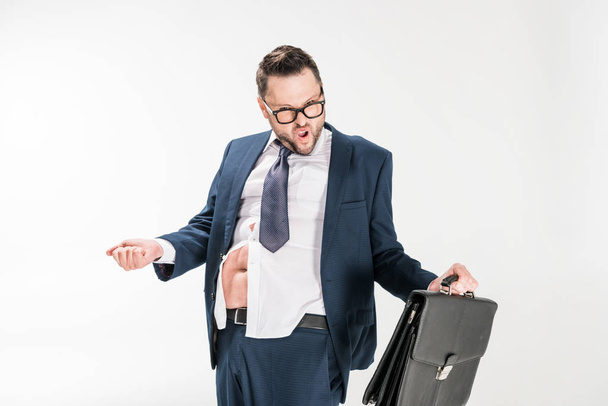 hombre de negocios con sobrepeso en apretado desgaste formal y gafas que sostienen el maletín en blanco
 - Foto, imagen