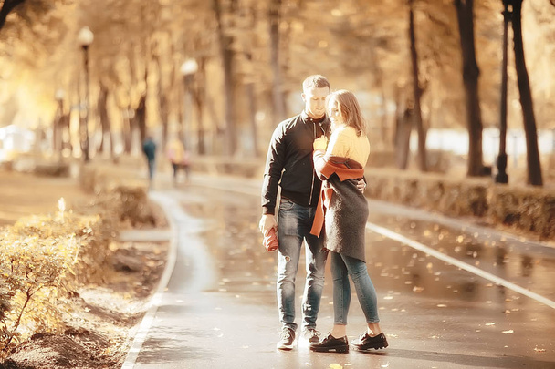 sun rays in the autumn park, a couple in love / young man and woman are walking, autumn view of the sunny park, the rays of the sun, warm autumn background - Photo, image
