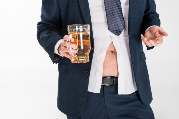 abgeschnittene Ansicht eines übergewichtigen Mannes in formeller Kleidung, der ein Glas Bier hält und isoliert auf Weiß gestikuliert - Foto, Bild