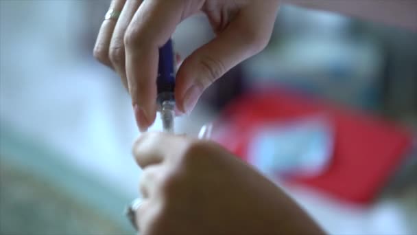 Women's hands are recruited from an open ampoule of medicine in a medical syringe, releases the air from it, the nurse prepares the vaccine for the injection - Video