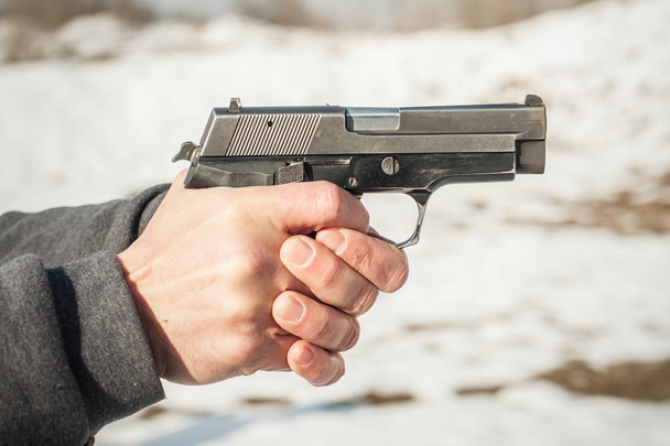 Close-up detail view of shooter hands holding gun and shooting - Photo, Image