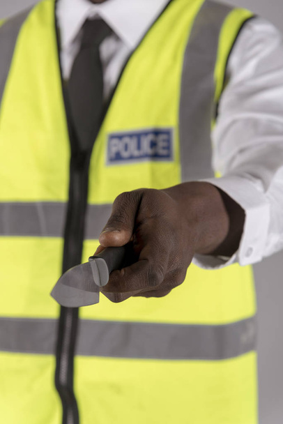Salisbury, Wiltshire, Royaume-Uni. Avril 2019. Officier de police tenant un couteau de cuisine étriqué
 - Photo, image